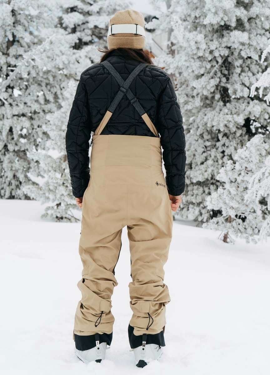 Burton Women's AK Gore-Tex Kimmy Bib Pant 2023 - Black bib with tan accents and black zippers on side pockets.