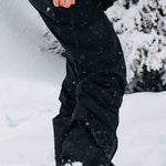 Burton Women's AK Gore-Tex Kimmy Bib Pant 2023 - Black snow pants with white stitching and a zippered pocket on the right thigh.