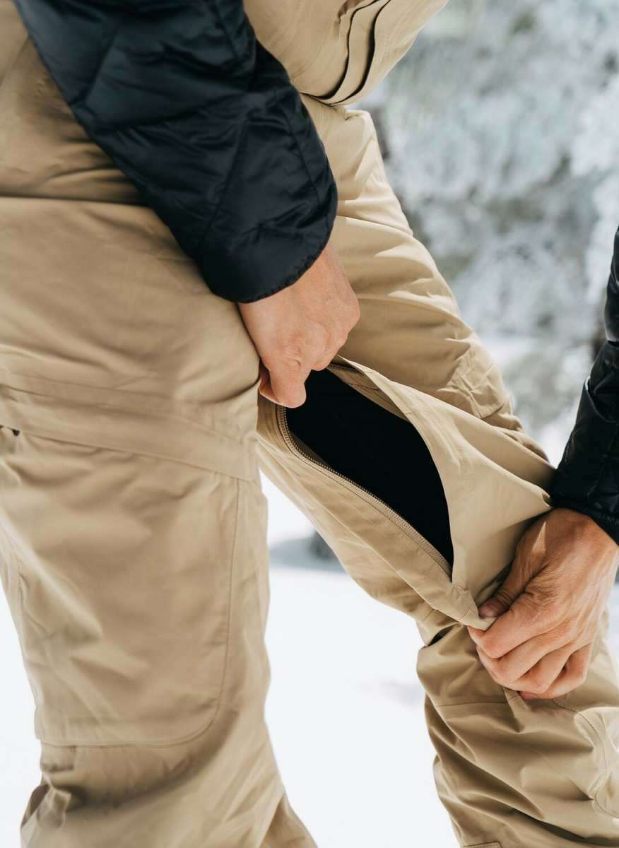 Burton Women's AK Gore-Tex Kimmy Bib Pant 2023 - A pair of khaki-colored snow pants with a zippered fly and adjustable Velcro straps at the waist.