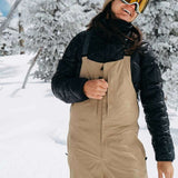 Burton Women's AK Gore-Tex Kimmy Bib Pant 2023 - A pair of tan snow pants with a black quilted pattern on the upper thigh area.
