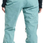 Burton Women's Gloria 2 Layer Stretch Pant 2024 - A pair of light blue snow pants with a black logo on the left thigh and a zippered pocket on the right hip.