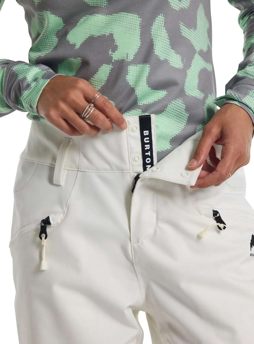 Burton Women's Marcy High Rise Stretch Pants 2024 - A pair of white snowboard pants with a black tag on the waistband that says "BURTON" in white letters.