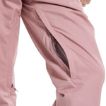 Burton Women's Marcy High Rise Stretch Pants 2024 - A pair of high-rise, pink ski pants with a zippered pocket on the side and adjustable cuffs at the bottom.