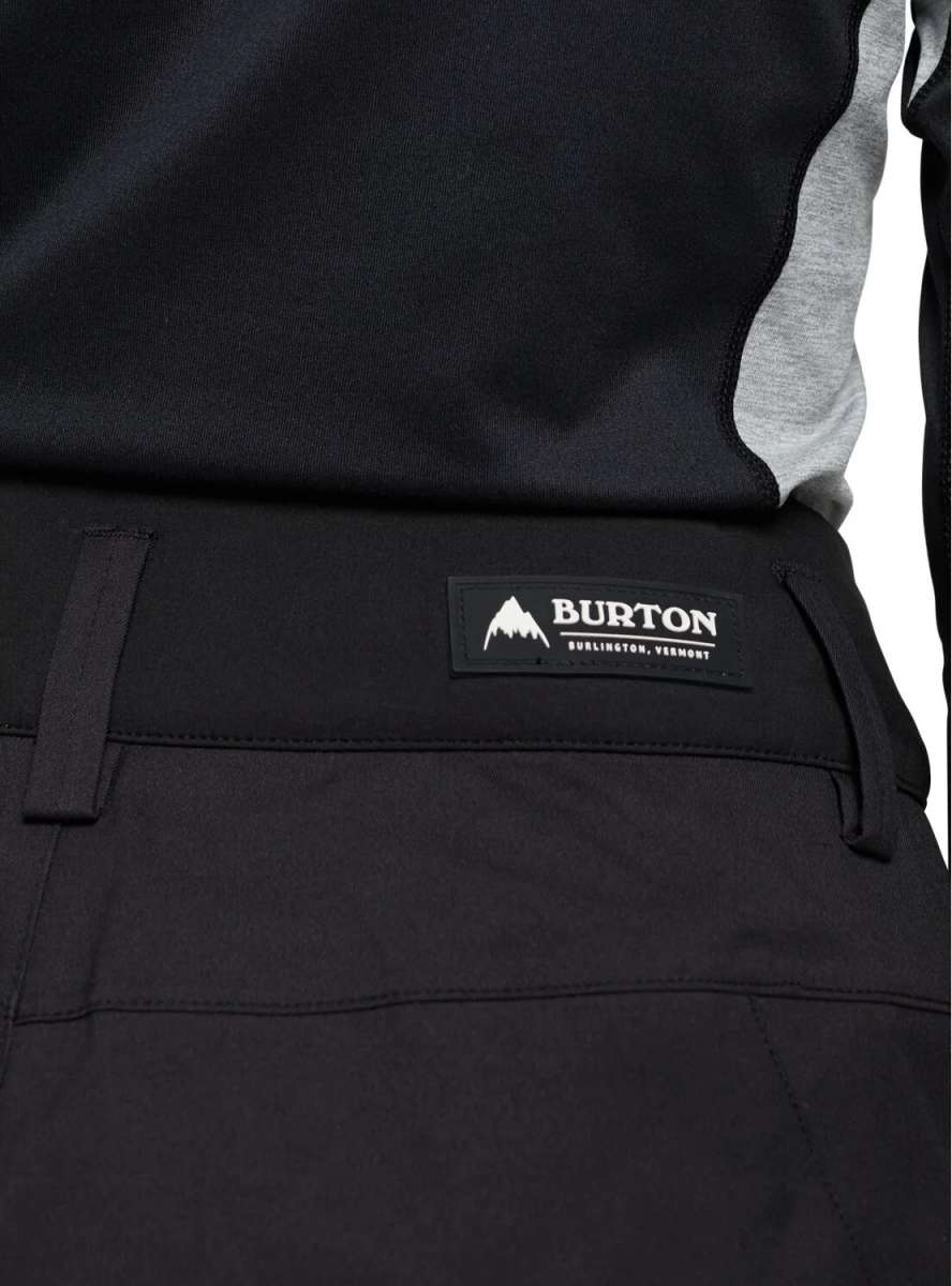 Burton Women's Marcy High Rise Stretch Pants 2024 - Black pants with a white logo on the left thigh and gray accents along the sides.