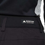 Burton Women's Marcy High Rise Stretch Pants 2024 - Black pants with a white logo on the left thigh and gray accents along the sides.