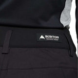 Burton Women's Marcy High Rise Stretch Pants 2024 - Black pants with a white logo on the left thigh and gray accents along the sides.