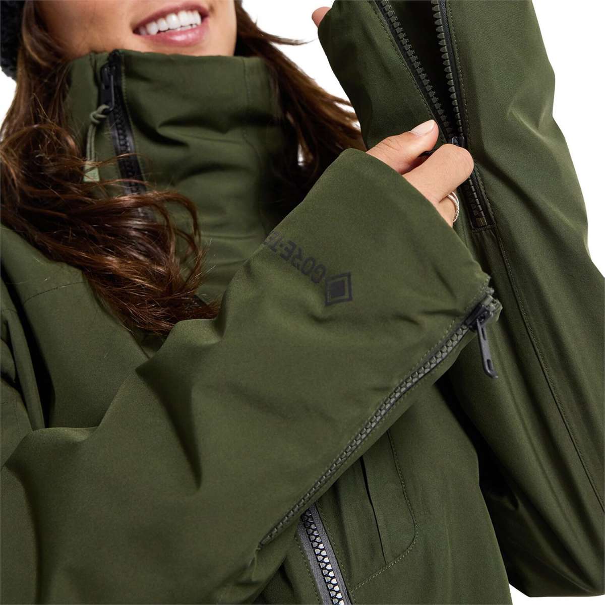 Burton Women's Pillowline GORE-TEX Insulated Jacket 2024 - A dark green jacket with a high collar and zippered pockets, featuring a black zipper on the chest.