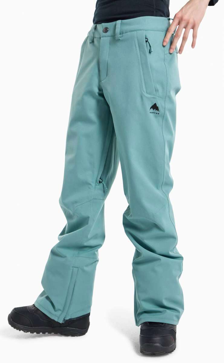 Burton Ladies Society 2L Insulated Pant 2024 - A pair of light blue snow pants with a black logo on the left thigh and two zippered pockets on the back.
