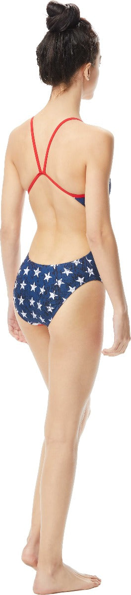 TYR Ladies' Star Spangled Cutoutfit Swimsuit - A navy blue swimsuit with white stars and red trim, featuring cutouts on the sides.