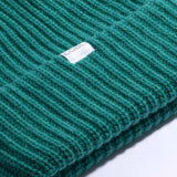 Coal Dan Mid Length Beanie 2023 - A green beanie with a ribbed cuff and a small white label on the front.