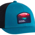 Coal Hauler Low One Cap 2024 - A blue cap with a black mesh back and a rectangular patch on the front featuring a red sunset over mountains, with a green silhouette of a mountain range below it.