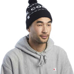 Coal Kelso Tall Pom Beanie - Black beanie with white lettering and a black pom-pom on top.