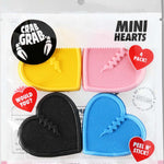 Crab Grab Mini Hearts Stomp Pad 4 Pack 2022-2023 - Four heart-shaped pads in pink, blue, yellow and black.