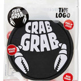 Crab Grab The Logo Stomp Pad 2024 - Black crab grab logo on a round, black stomp pad with serrated edges.