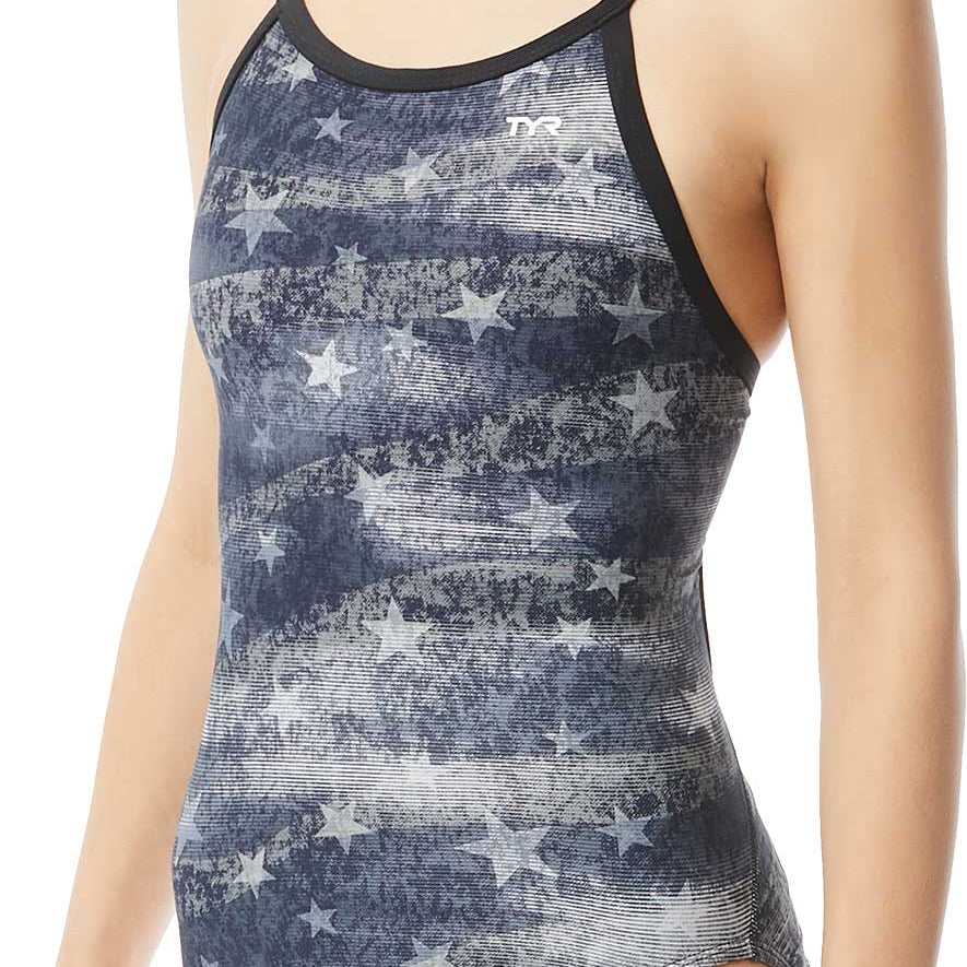 TYR Ladies' American Dream Diamondfit Swimsuit - A navy blue swimsuit with a pattern of faded white stars and stripes, featuring thin straps and a TYR logo on the upper left side.