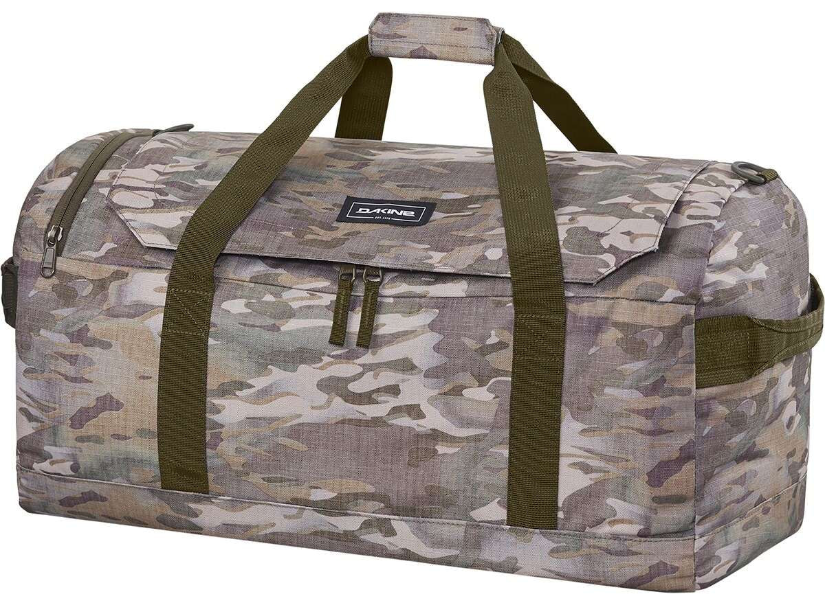 Dakine EQ Duffle 50L 2022-2023 - A large, rectangular duffel bag with a zippered top and two dark green shoulder straps. It has a small black label on the front that reads "DAKINE" in white letters. The bag is made of a camouflage material featuring shades of brown, tan, and gray.