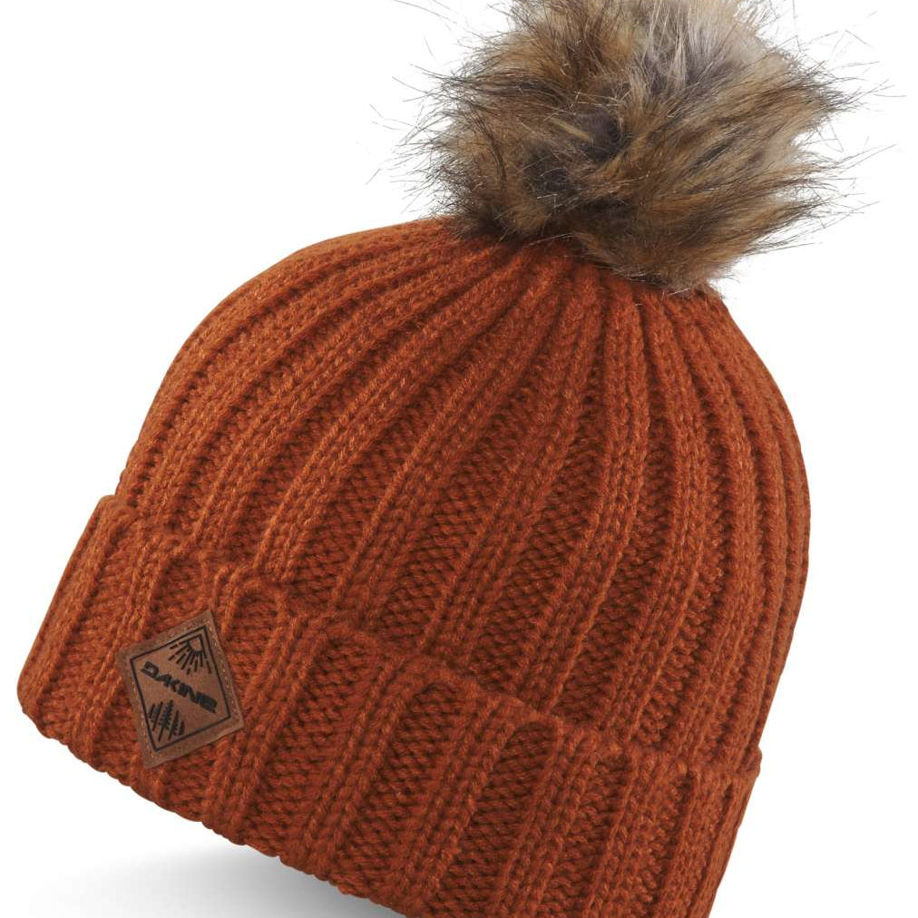 Dakine Ladies Kylie Beanie 2024 - A rust-colored beanie with a brown faux fur pom-pom on top.