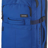 Dakine Split Roller 85L 2022-2023 - A large blue roller bag with black wheels and handle, featuring a zippered front pocket and two side pockets.