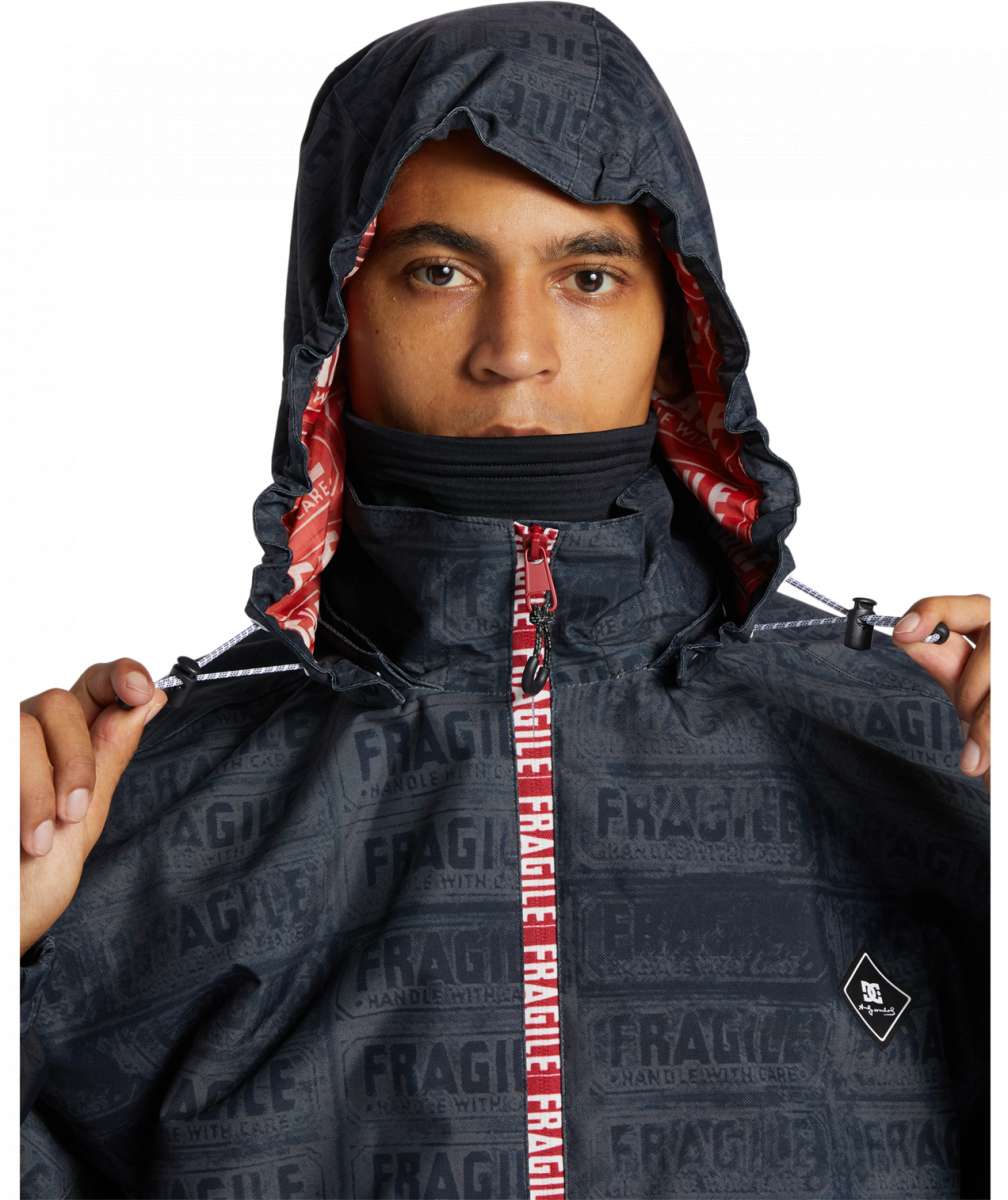 DC AW Vista Shell Jacket 2024 - A black jacket with a repeating pattern of white "Fragile" labels and a red zipper pull.