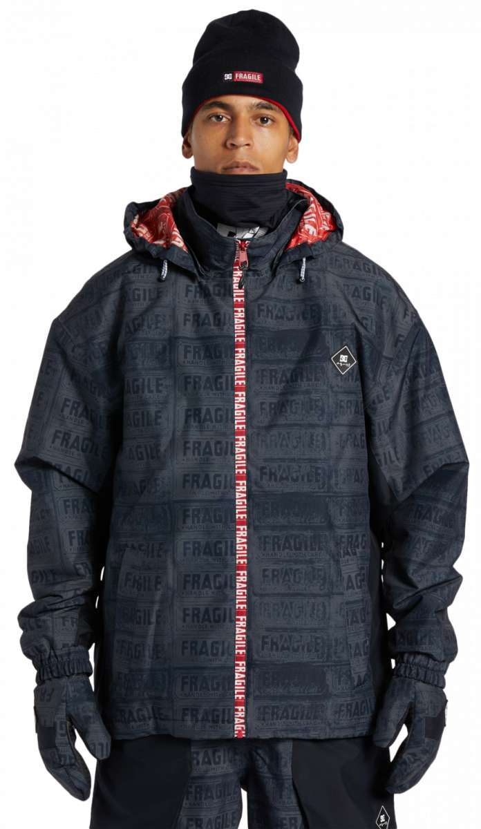 DC AW Vista Shell Jacket 2024 - A black jacket with a repeating pattern of "DC" and "AW" logos in white, featuring a red zipper pull.