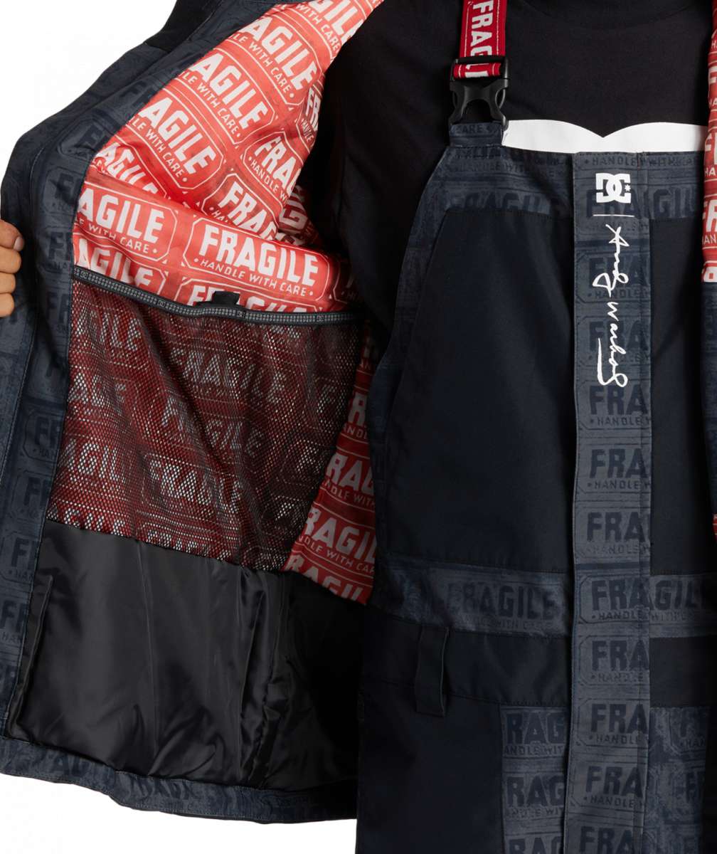 DC AW Vista Shell Jacket 2024 - A black jacket with a red zipper and white logo on the left chest.