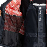 DC AW Vista Shell Jacket 2024 - A black jacket with a red zipper and white logo on the left chest.