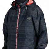 DC AW Vista Shell Jacket 2024 - A black jacket with a repeating pattern of "FRAGILE" labels in gray, featuring red accents on the hood and zipper.