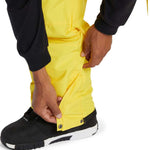 DC Banshee Insulated Pant 2024 - Yellow snow pants with black trim and silver snap buttons on the side of one leg.