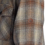 DC Canyon Full Zip Flannel 2024 - A plaid flannel jacket with a full zip and two chest pockets, featuring a brown, white, and black color scheme.
