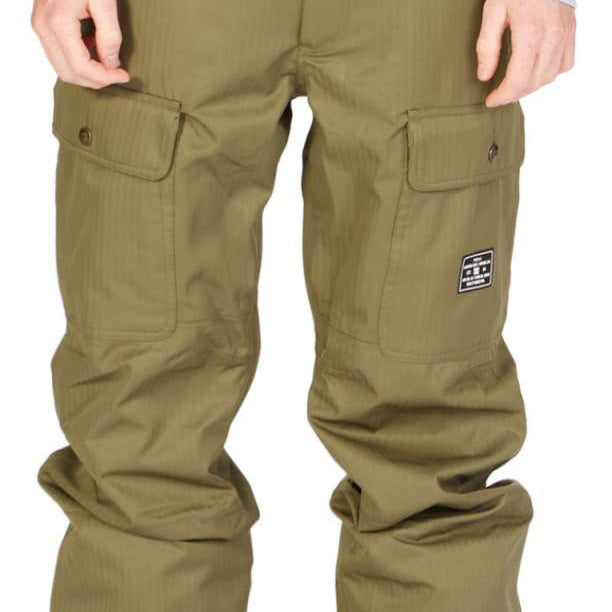 DC Code Shell Pant 2023 - A pair of olive green snow pants with a subtle vertical stripe pattern and two zippered cargo pockets on each thigh.