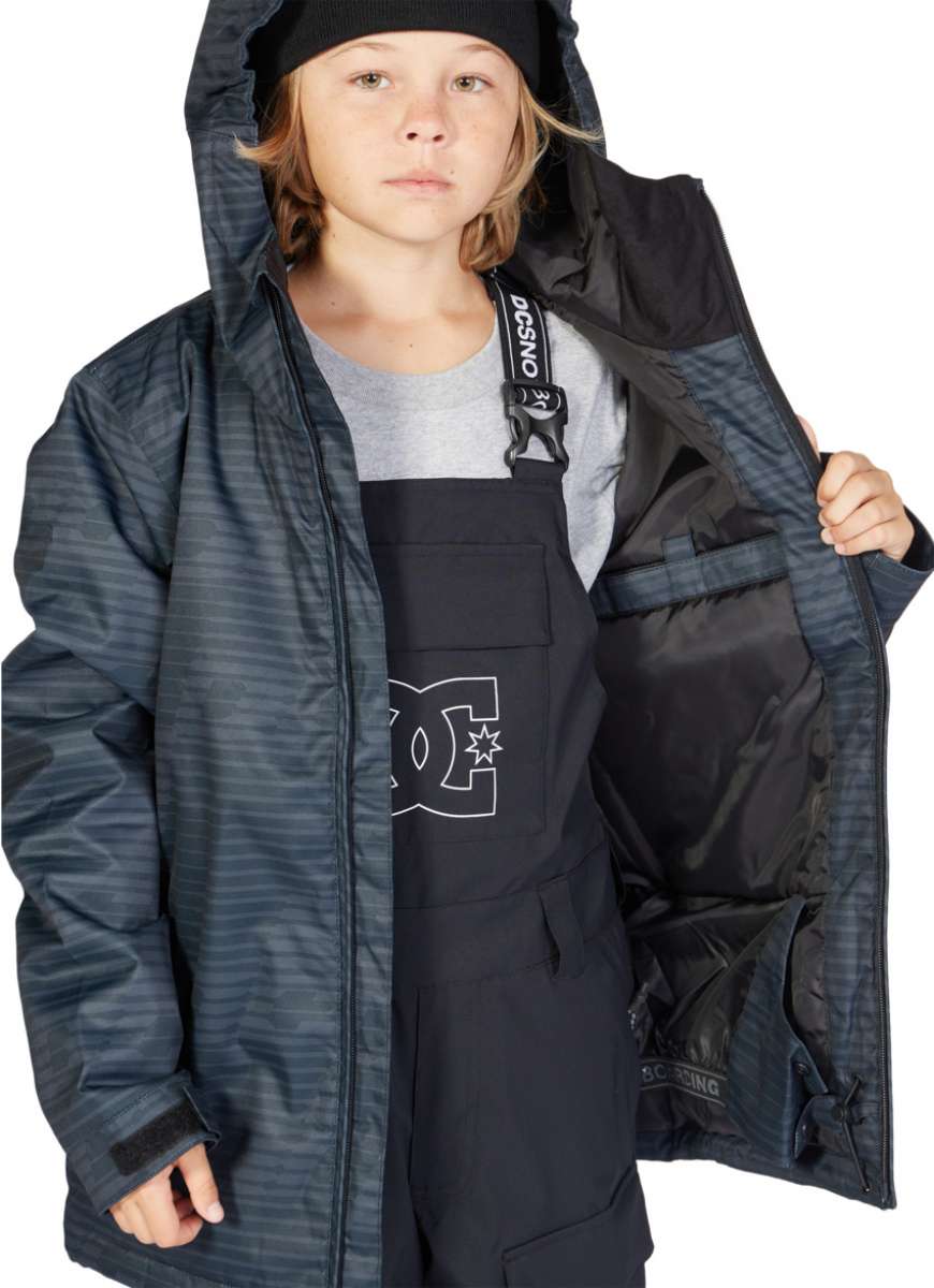 DC Juniors Propaganda Insulated Jacket 2023 - A black and white striped jacket with a hood, worn by a young girl with blonde hair.