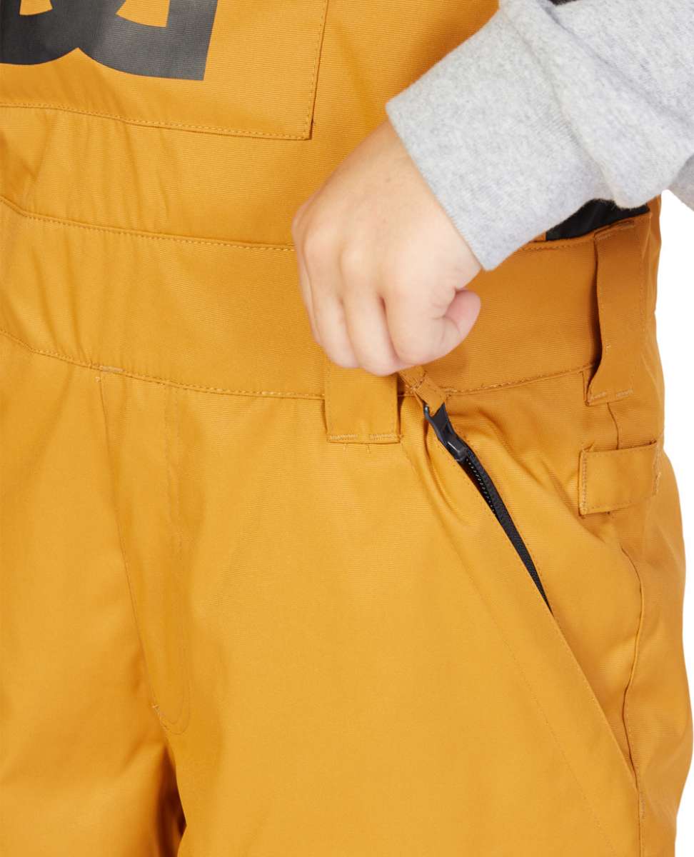 DC Juniors Roadblock Bib 2023 - A pair of yellow snow pants with a black zipper on the side pocket.