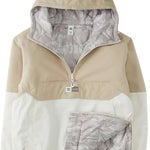 DC Women's Nexus Reversible Anorak Jacket 2024 - A tan and white jacket with a hood, featuring a zipper closure at the front.