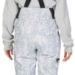 DC Women's Collective Shell Bib 2023 - White snow pants with a subtle gray pattern of abstract shapes and lines, featuring black suspenders and gold buckles.