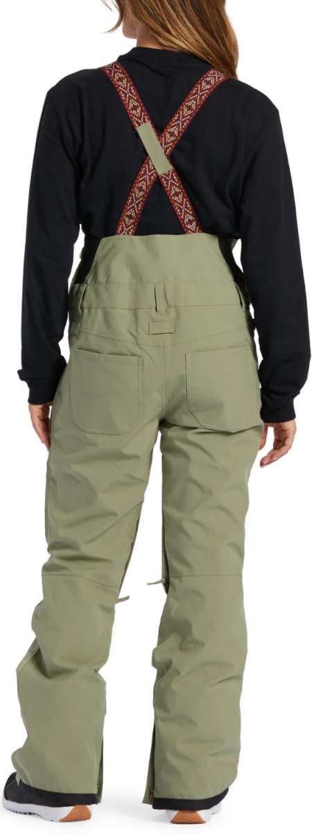 DC Women's Crusade Shell Bib Pant 2024 - Black bib with white and red geometric patterned straps, black waistband, and zippered leg pockets.