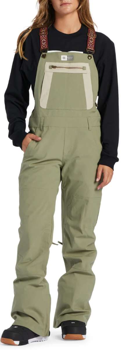 DC Women's Crusade Shell Bib Pant 2024 - A pair of khaki green snow pants with a zippered pocket on the thigh and adjustable straps at the waist.