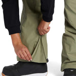 DC Women's Crusade Shell Bib Pant 2024 - A pair of olive green snow pants with a zippered pocket on the thigh and adjustable velcro straps at the waist.