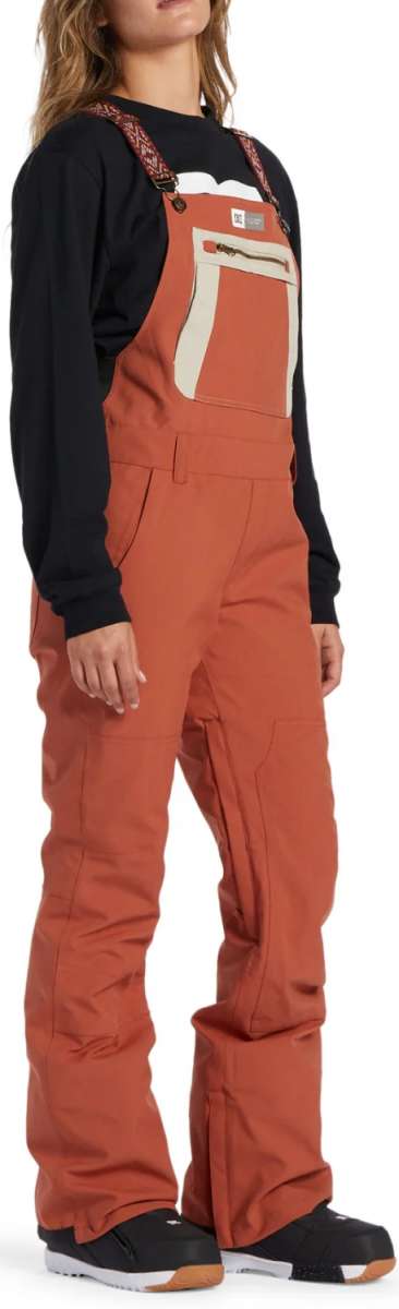 DC Women's Crusade Shell Bib Pant 2024 - A pair of burnt orange snow pants with a zippered pocket on the thigh and adjustable straps at the waist.