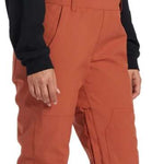 DC Women's Crusade Shell Bib Pant 2024 - A pair of burnt orange snow pants with a zippered pocket on the thigh and adjustable straps at the waist.