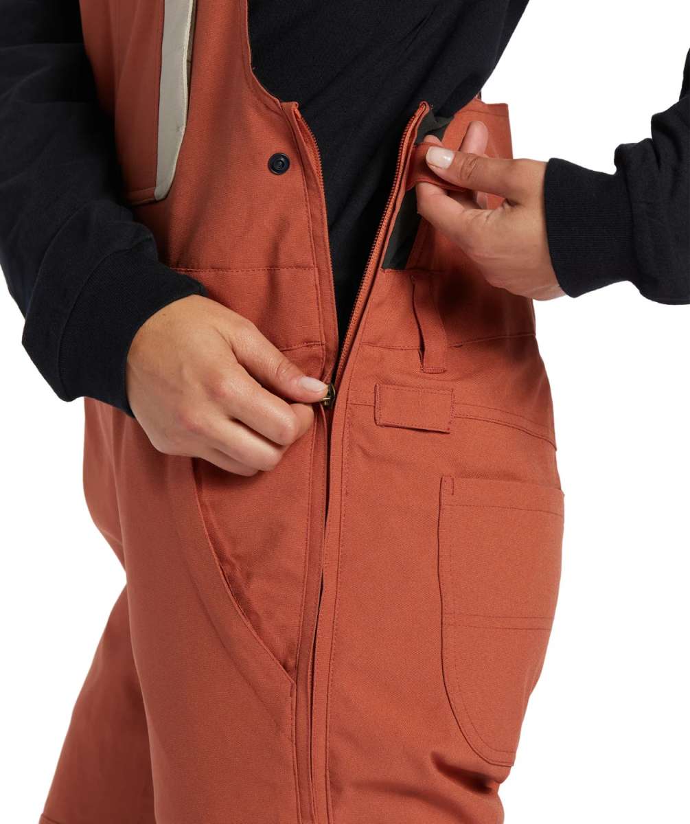 DC Women's Crusade Shell Bib Pant 2024 - A pair of burnt orange snow pants with a black zipper on the side.