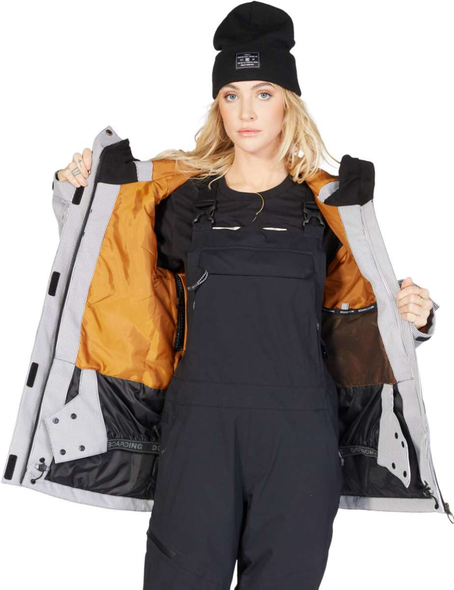 DC Women's Liberate Insulated Jacket 2023 - A black jacket with a white stripe on the left sleeve and a zippered pocket on the right side.