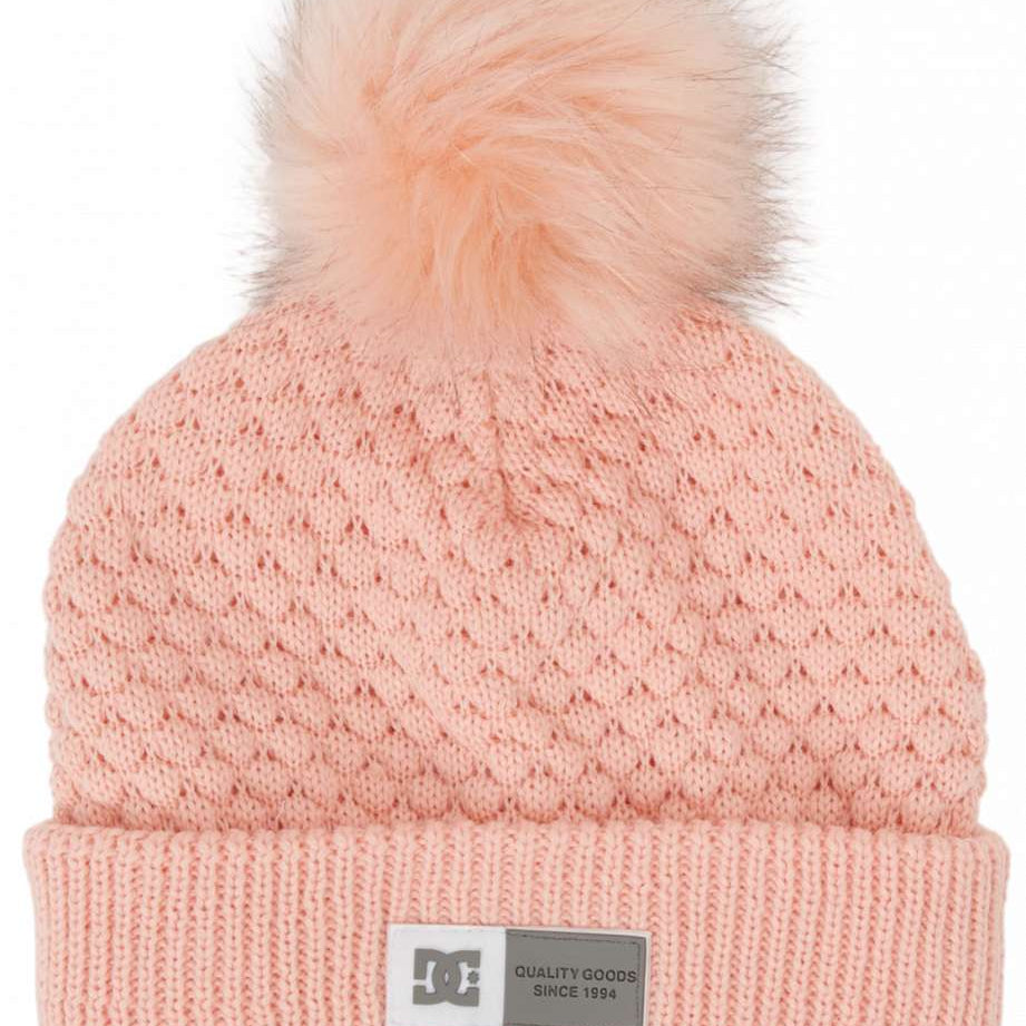DC Women's Splendid Beanie 2024 - A light pink beanie with a cable-knit pattern and a large, fluffy pom-pom on top.
