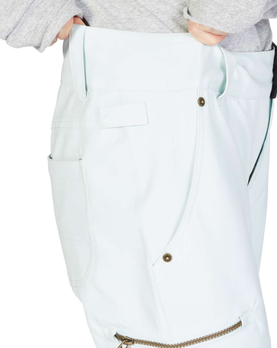 DC Women's Viva Shell Pant 2023 - White pants with a zippered pocket on the side and a small logo patch near the bottom hem.