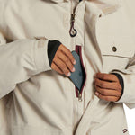 DC Servo Insulated Jacket - A cream-colored jacket with a black zipper and two chest pockets, one of which has a small black button on it.