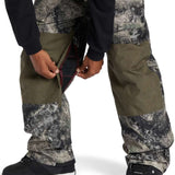 DC Shadow Shell Bib Pants 2024 - A pair of olive green snow pants with a subtle black and white marbled pattern on the lower legs.