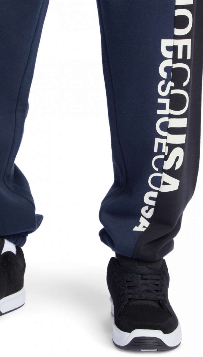 DC Static Sweatpants 2024 - Pair of navy blue sweatpants with white lettering down one leg.