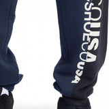DC Static Sweatpants 2024 - Pair of navy blue sweatpants with white lettering down one leg.