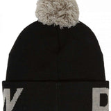 DC Youth Gambol Beanie 2024 - A black beanie with a white logo on the front and a large, fluffy pom-pom on top.