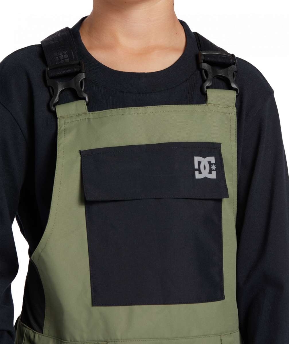 DC Youth Roadblock Insulated Bib 2024 - A pair of olive green insulated bib overalls with a black logo on the left leg and adjustable straps.