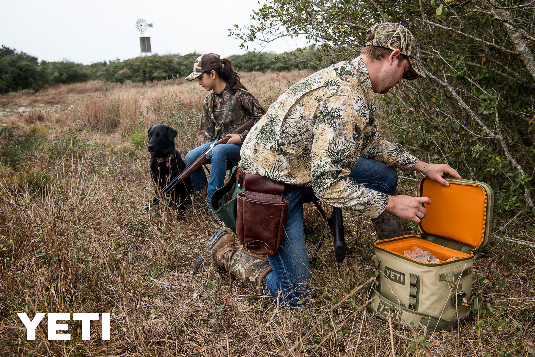 Yeti Hopper Flip 18 Personal Cooler - A tan cooler with a black zipper and handle, sitting on a wooden dock near a body of water.